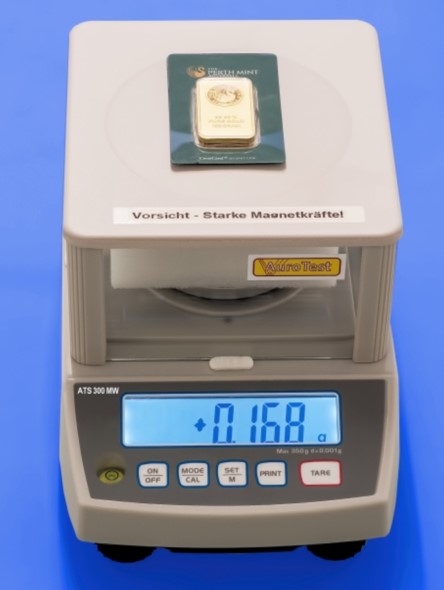 Gold bar authenticity test on a scale showing a certified measurement result.